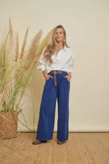 Pantalón de pana fina color azul, de pierna ancha, con elástico en la cintura y bolsillos laterales. Incluye un cinturón de cuero marrón.