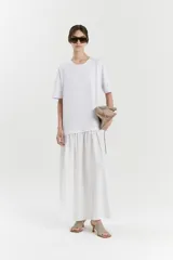 Vestido blanco de corte midi, compuesto por una remera de algodón de manga corta y una falda de poplín con frunces.