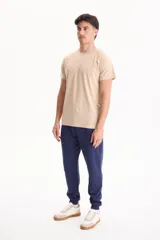 Remera de manga corta color beige, con cuello redondo y diseño clásico.