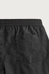 Short de baño de color azul marino, confeccionado en tejido técnico, con cintura elástica ajustable mediante cordón, bolsillos laterales y detalle de bolsillo trasero.