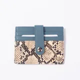 Tarjetero celeste y con estampado animal print de serpiente, con ranuras para tarjetas y tira con botón a presión.