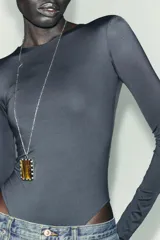 Body de manga larga confeccionado en mezcla de poliamida, con cuello redondo y cierre inferior con botones a presión.