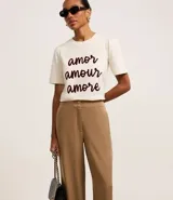 Pantalón wide leg color marrón claro, de tiro alto, con cierre tradicional y doble botón en la cintura.