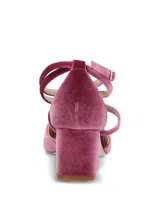 Zapato de tacón medio y puntera fina, confeccionado en terciopelo color fucsia, con tiras cruzadas en el empeine y doble tira con hebilla ajustable alrededor del tobillo.