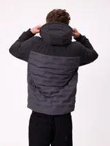 Campera con capucha, diseño bicolor en negro y gris oscuro, con panel frontal acolchado y mangas lisas. Cuenta con cierre frontal, bolsillos laterales y puños elásticos.