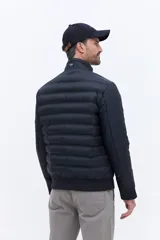 Campera puffer de nylon color beige, con diseño minimalista, cuello alto, cierre frontal y puños elásticos. Presenta logo de la marca bordado en el pecho.