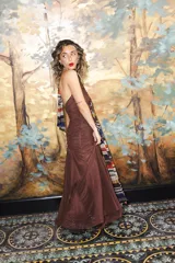 Vestido largo de encaje y transparencias color marrón, con escote profundo halter, frunces en el cuerpo, espalda abierta y tiras largas estampadas para atar al cuello.
