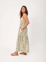 Vestido largo de algodón con estampado estilo patchwork en tonos verde y beige, escote en V con tirantes finos ajustables, diseño holgado y falda escalonada con bolsillos laterales.