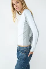 Remera de manga larga color blanco melange, con cuello redondo y diseño acanalado rib 2x2. Presenta un fit ajustado que acompaña la silueta.