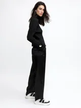 Pantalón palazzo negro de raso con bolsillos laterales.