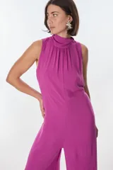 Mono marrón sin mangas, con cuello alto fruncido y lazo en la cintura.