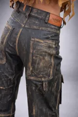 Pantalón cargo de cuero con efecto desgastado, de tiro medio y silueta recta amplia. Presenta múltiples bolsillos cargo con solapa y herrajes metálicos en el frente, además de bolsillos traseros de gran tamaño.