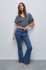 Jean flare de tiro medio, color azul, confeccionado en denim con elasticidad, calce al cuerpo hasta la rodilla y pierna levemente acampanada.
