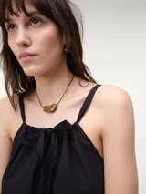 Vestido corto de popelina de algodón color arena, con diseño fluido, breteles finos y detalle de lazo ajustable en el escote.