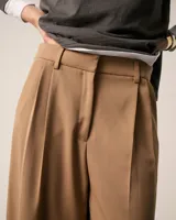 Pantalón sastrero pinzado gris, confeccionado en tela italiana, de tiro medio/alto y largo hasta los tobillos. Silueta baggy, cintura prearmada, cartera con cierre y botón, bolsillos laterales funcionales, doble pinza en cada pierna, pinzas en la espalda y bolsillo ojal con presilla y botón.