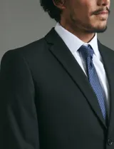 Traje de corte slim fit compuesto por saco de dos botones y pantalón de vestir a juego. Presenta una silueta entallada y moderna.