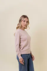 Buzo de punto color rosado, con cuello redondo, manga larga y corte recto.