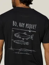 Remera negra de manga corta con estampado gráfico en la espalda que incluye la frase 'Bo, hay pique!' y dibujos de peces con una caña de pescar.