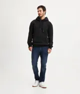 Pantalón de jean corte slim, color azul oscuro, con cierre frontal de botones y cremallera, bolsillos laterales y trabillas para cinturón.