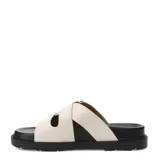 Sandalias Miss Carol modelo Brix, color marfil, con dos tiras cruzadas ajustables mediante hebillas metálicas plateadas y suela plana de goma negra.