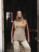 Buzo tejido de punto color crema con cuello alto y mangas largas con rayas horizontales en verde y lila.