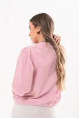 Camisa de manga larga con diseño a rayas rojas y blancas, cuello camisero y cierre frontal con solapa.