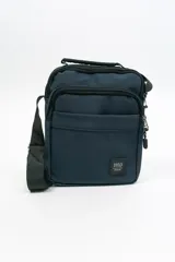 Morral de diseño compacto en color azul marino, con múltiples compartimentos con cierre, manija superior y correa ajustable para llevar al hombro. Incluye etiqueta con logo de la marca en la parte frontal.
