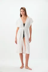 Túnica blanca de ratier de algodón con detalles de puntilla en el escote y lazo para ajustar en la cintura.