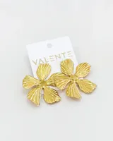 Aros colgantes dorados en forma de flor con textura estriada en los pétalos.