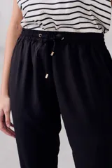 Pantalón negro de viscosa con cintura elastizada y cordón ajustable.