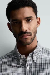 Camisa de corte regular fit confeccionada en tejido de algodón con efecto lavado. Presenta cuello abotonado, manga larga con puños abotonados, bolsillo en el pecho y cierre frontal con botones.