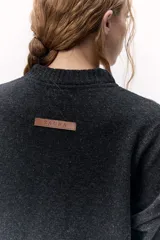 Sweater de lana color crema, de cuello alto y corte holgado.