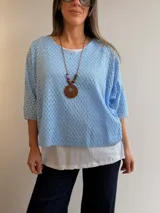 Buzo azul marino con diseño calado de manga corta y corte oversize, acompañado por una musculosa blanca básica interior.