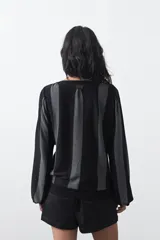 Sweater de tejido de punto con hilo metalizado, color marrón, con cuello redondo y mangas largas abullonadas con puños ajustados.