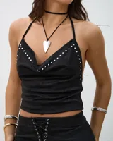 Top negro de estilo halter con escote drapeado y detalle de tachas metálicas plateadas en los bordes. Confeccionado en un tejido suave tipo gamuza.