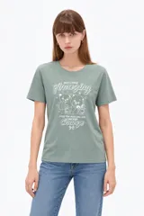 Remera de manga corta color verde militar, con cuello redondo y diseño holgado. Presenta estampado frontal con ositos y texto con detalles de glitter.