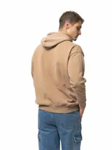 Buzo canguro con capucha, bolsillo frontal tipo canguro y cordones ajustables. Presenta un corte holgado y puños con rib acanalado.