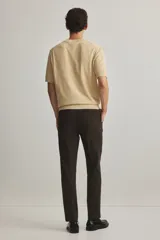 Pantalón sastrero de corte ajustado, con cierre de botón, bolsillos laterales y bolsillos traseros ribeteados.