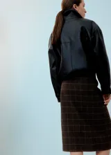 Falda midi de corte recto con diseño a cuadros en tonos marrones y negros, con una abertura frontal central.