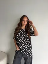 Remerón de viscosa color bordó con estampado de lunares pequeños blancos, cuello redondo y mangas cortas de corte holgado.