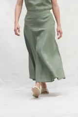 Falda midi color verde oliva, de lino, con corte a la cintura y diseño con paneles curvos.