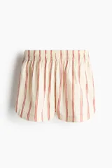 Short de popelina de algodón de tiro alto con cintura fruncida y bolsillos laterales discretos, de bajo levemente redondeado. Presenta un diseño de rayas verticales sobre base beige.