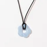 Collar con cordón negro y dije de flor celeste.