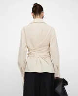 Camisa de algodón color beige, de línea semientallada, con cuello italiano, manga larga y detalle cruzado con lazo para anudar en el lateral.