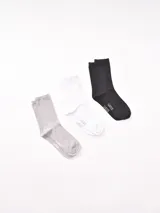 Pack de tres pares de medias de caña corta, una gris, una blanca y una negra, con logo de la marca en el tobillo.