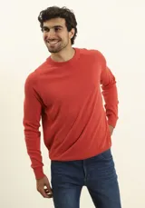 Sweater de punto color naranja, con cuello redondo y mangas raglán.