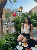 Top corto negro con escote drapeado y espalda descubierta.