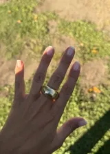 Anillo de diseño orgánico con pieza ovalada de superficie lisa y brillante. Posee una estructura abierta que permite ajustar su tamaño al dedo.