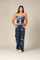 Pantalón de jean de pierna ancha con estampado batik azul y blanco, corte bajo, cintura elástica con cordón ajustable, bolsillos laterales y aberturas laterales en el ruedo.