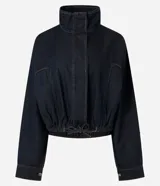 Chaqueta bomber de denim azul oscuro con cuello alto, cierre frontal con zíper y cintura ajustable con cordón. Presenta mangas largas con puños elásticos y bolsillos frontales funcionales.